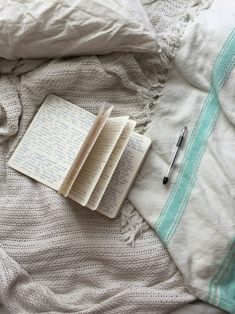 Open journal, pen, on a bed, ready for prayer journaling